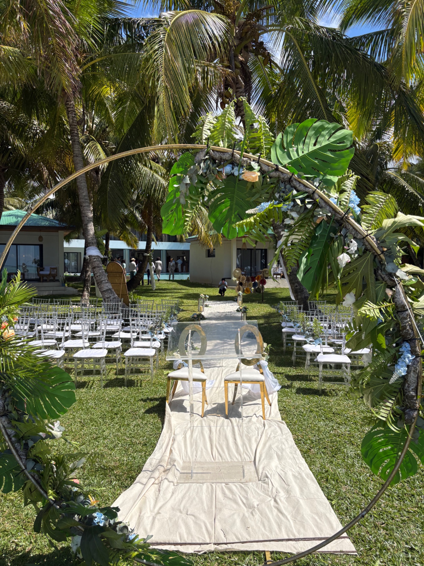 Floral arch and aisle set up on the lawn in front of the villa