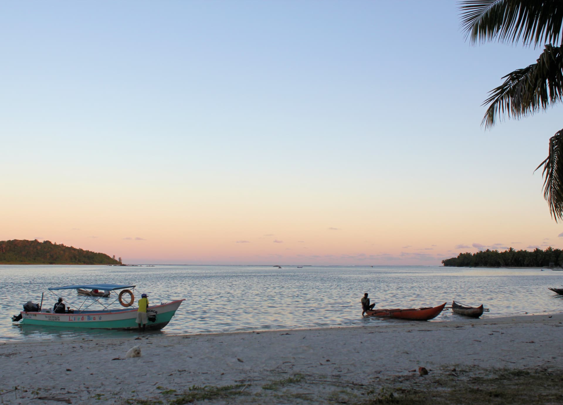A wooden pirogue crossing the glass-clear lagoon
